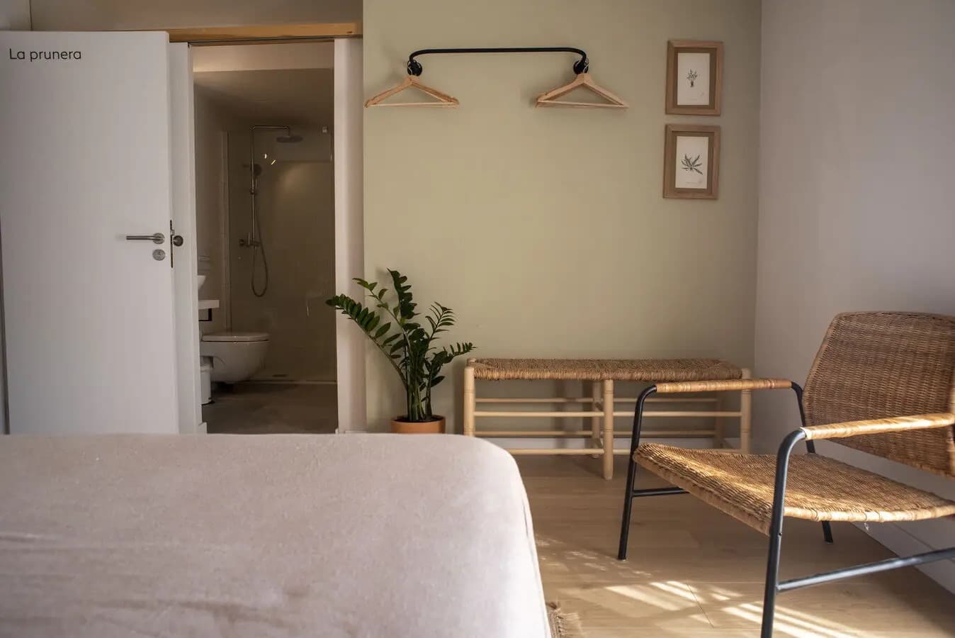 Mas de l'Illa — habitación La Prunera: detalle con pared sage y ratán